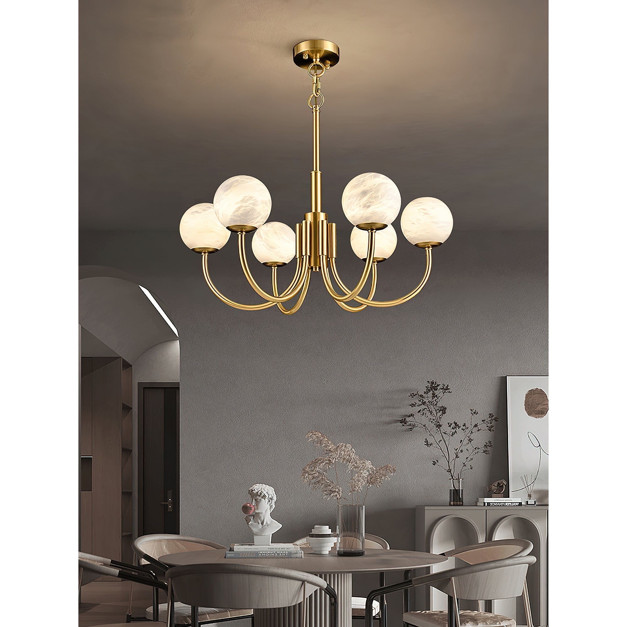 Clérachic lit above a round dining table and chairs, with an arched doorway and sideboard behind