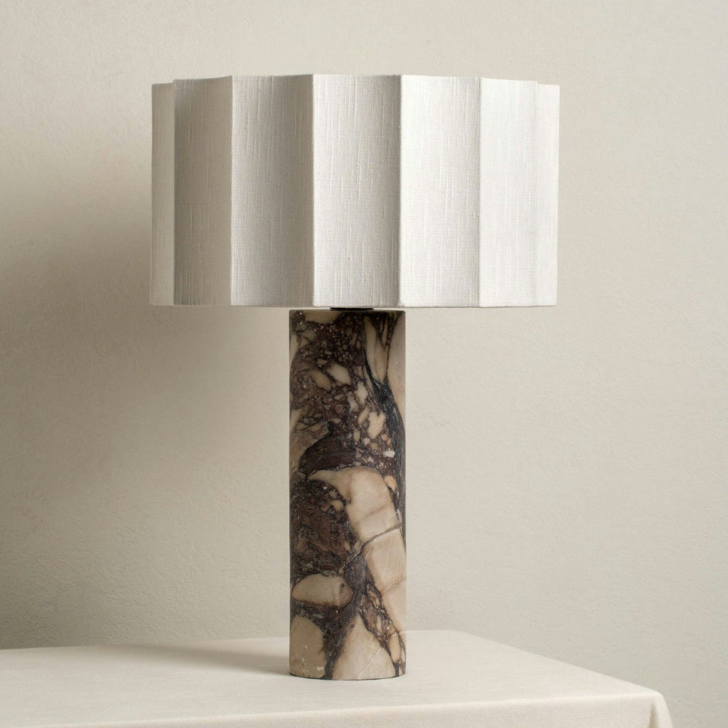 Unlit close-up of the Clérachic table lamp showing the faceted shade and the purple marble column's dark veining.