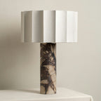 Unlit close-up of the Clérachic table lamp showing the faceted shade and the purple marble column's dark veining.