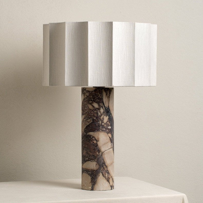The Clérachic table lamp shown unlit against a plain wall, highlighting the faceted shade's vertical pleats and base.