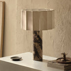 The Clérachic table lamp stands on a textured plaster-look console beside a small black dish and stacked magazines.