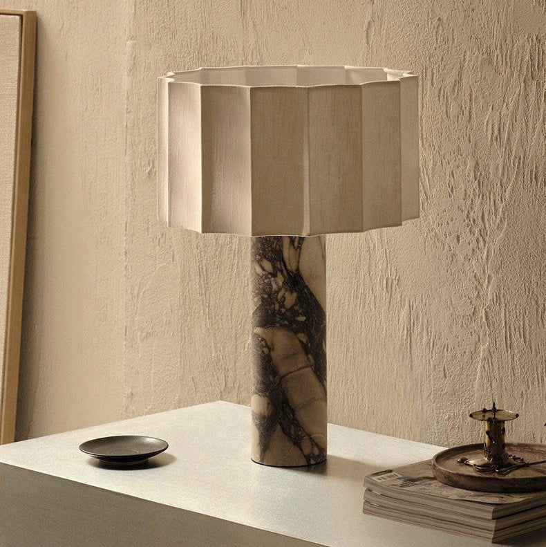 The Clérachic table lamp stands on a textured plaster-look console beside a small black dish and stacked magazines.