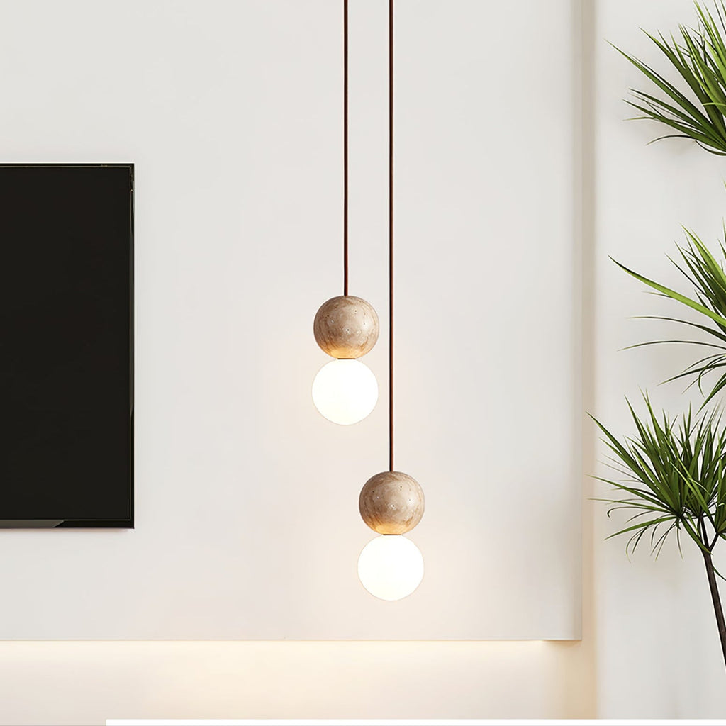 A staggered cluster of Clérachic pendants glows near houseplants and a wall-mounted television.