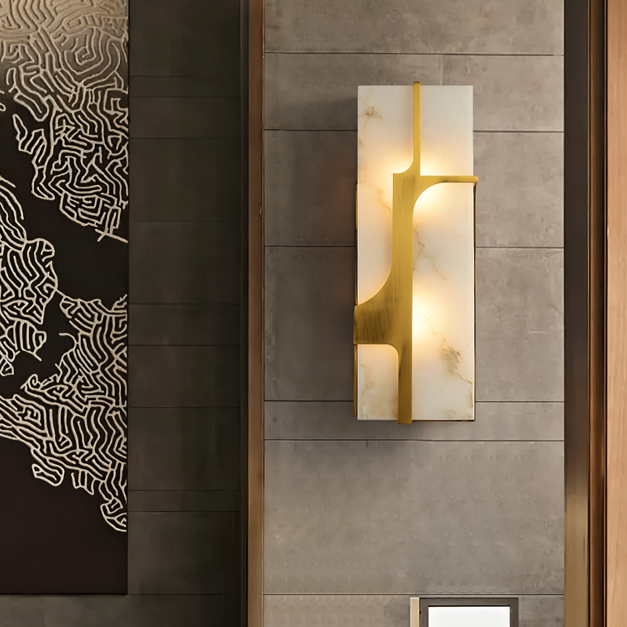 Closer square view of the lit Aurevon sconce on the same stone wall, brass bracket in detail