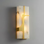 The Aurevon sconce lit, warm light spilling through the alabaster around its brass bracket