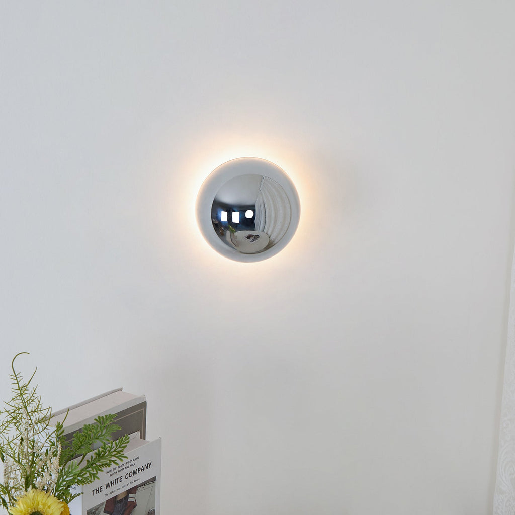 Polished sphere wall sconce in gold as a wall accent