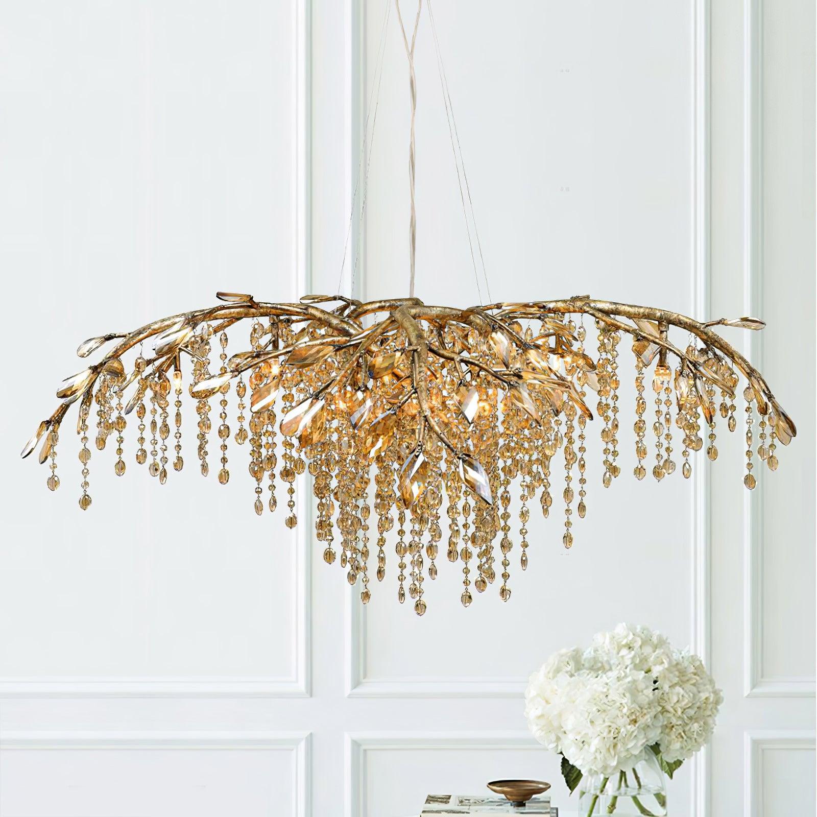 The gold chandelier lit against white panelling, white hydrangeas on the table below.