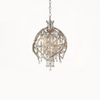 The round gold cage on white, hung from a chain with amber beads inside.