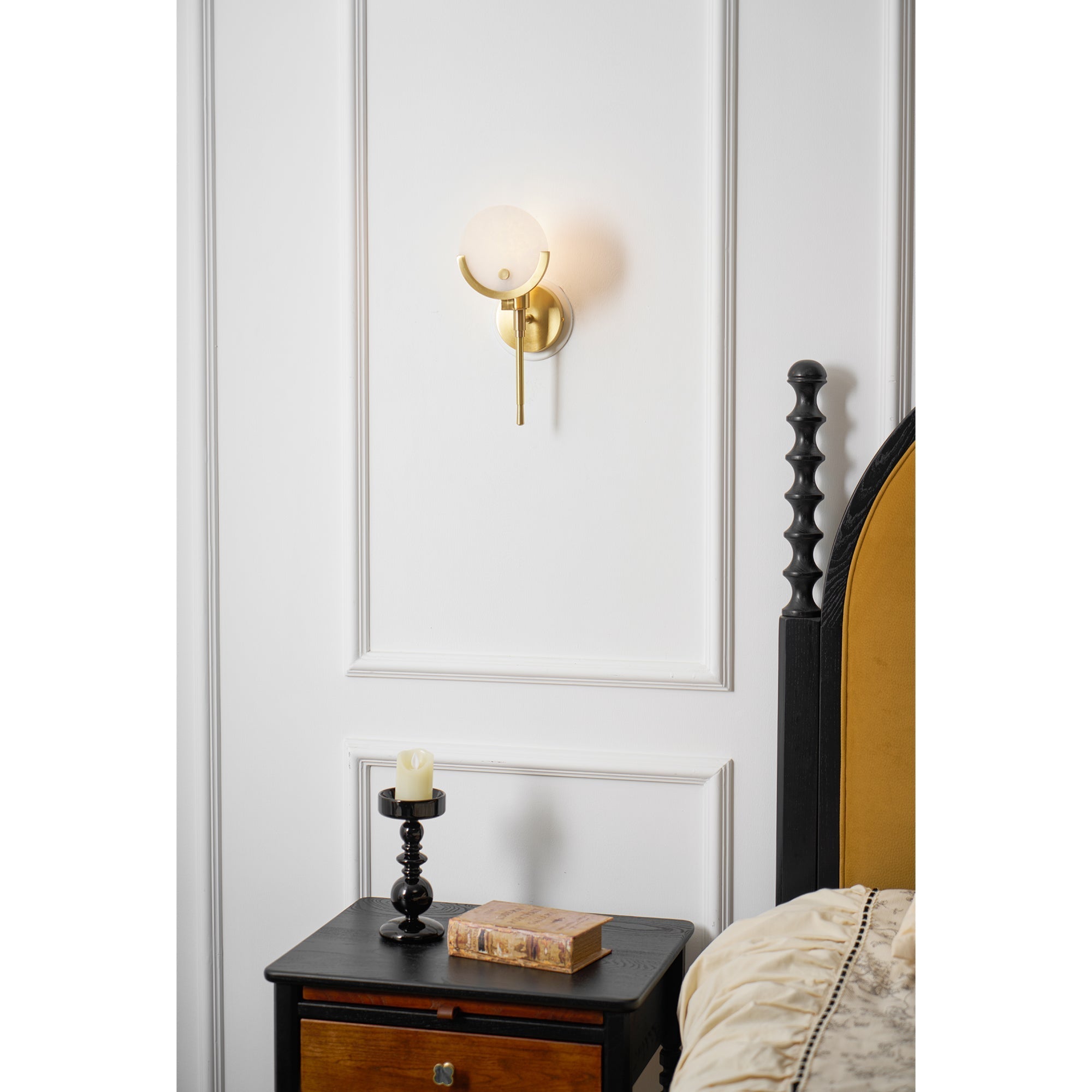 Clérachic closer bedroom crop of the Zavarara sconce lit on white panelling above an antique nightstand.