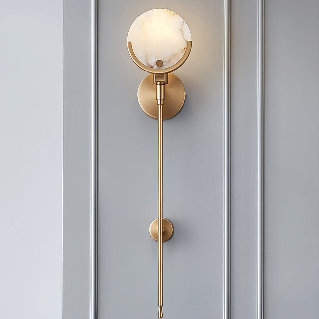 Clérachic straight-on view of the tall sconce lit against grey panelling, natural veining showing through the stone.