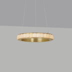 Brass alabaster chandelier switched on, stone tiles glowing warm against a grey studio backdrop.