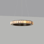 Dark bronze alabaster chandelier lit against a grey backdrop, warm glow inside a dark metal ring.