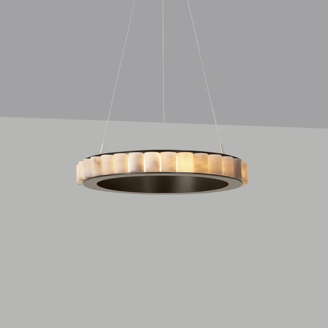 Dark bronze alabaster chandelier lit against a grey backdrop, warm glow inside a dark metal ring.