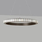 Large dark bronze alabaster chandelier unlit on a grey backdrop, stone tiles ringing the frame.
