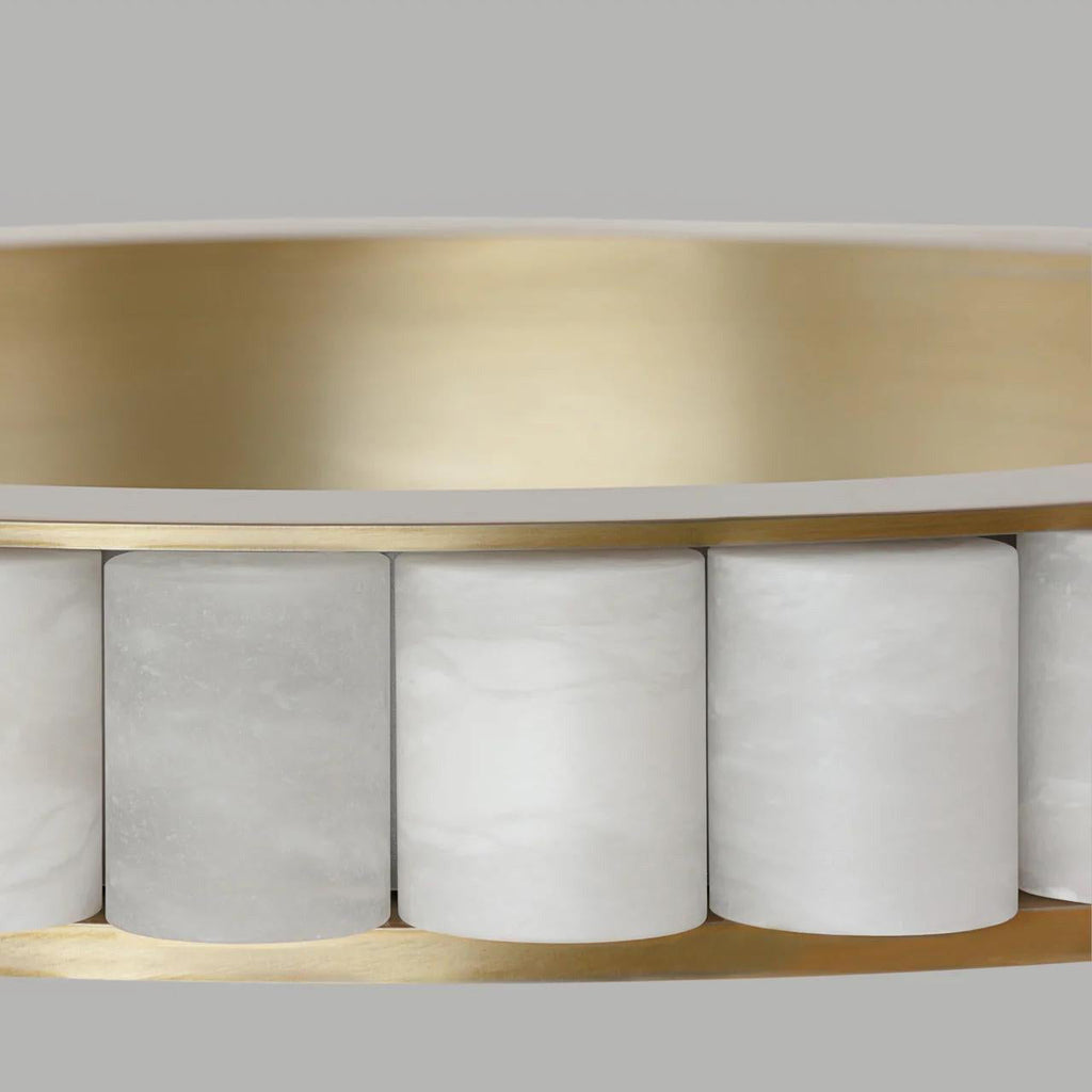 Close-up of the brushed brass band and the cylindrical alabaster tiles slotted along its edge.