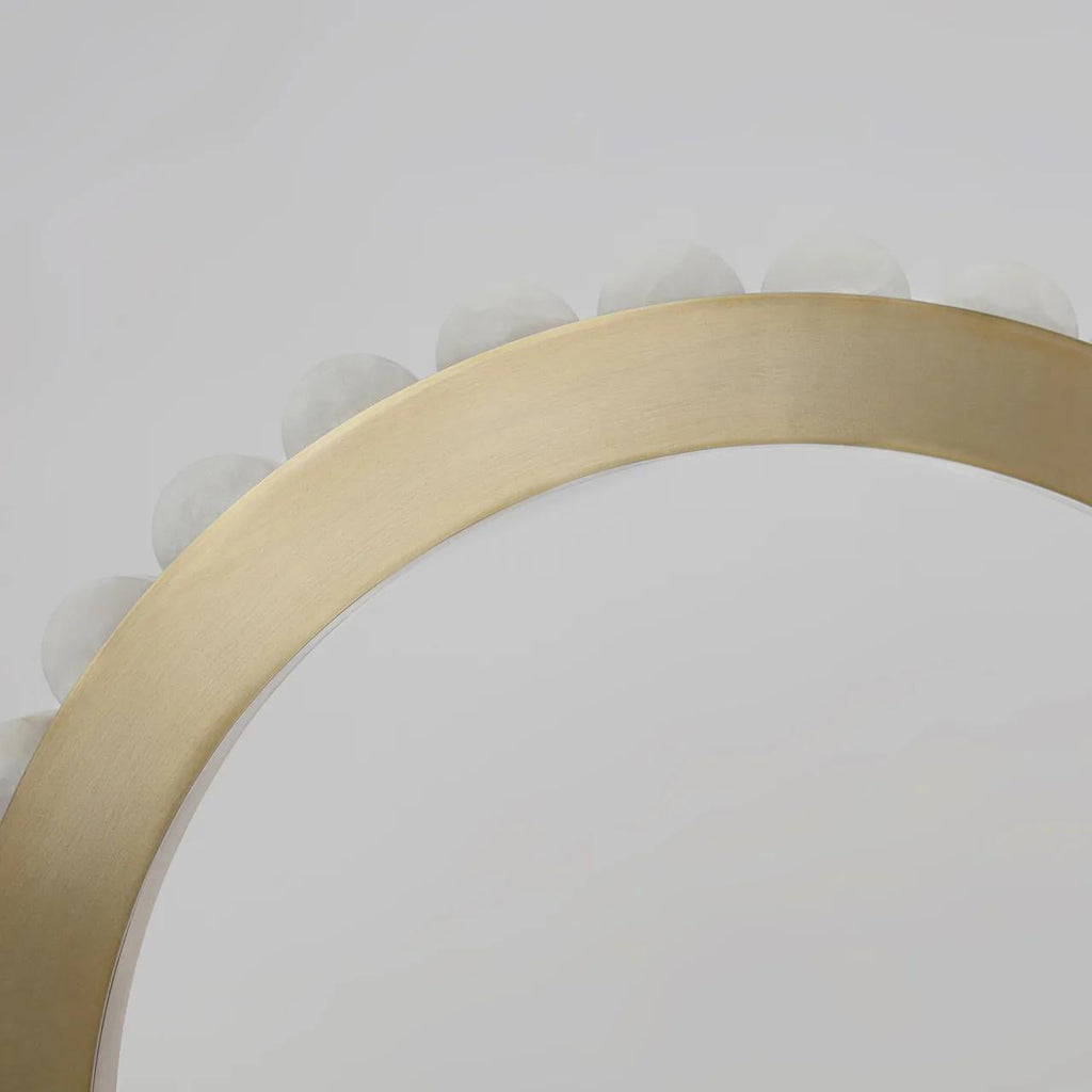 Overhead close-up of the brass ring curving away, alabaster tiles rising behind the metal band.