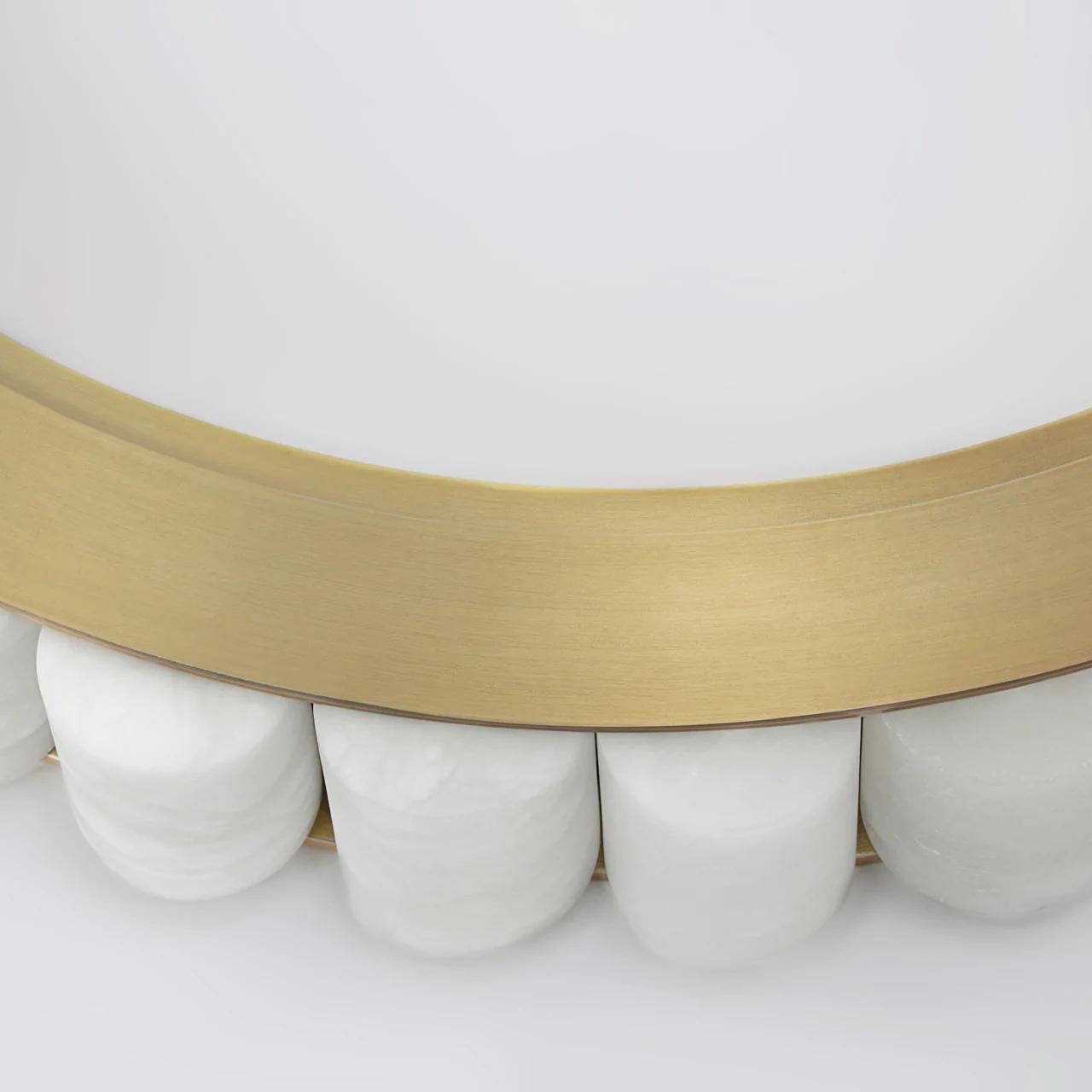 Detail of the brass rim seated on rounded alabaster tiles, showing how the stone is set.