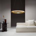 Brass alabaster chandelier lit above a white sofa in a living room with a dark brown wall.
