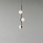 Baer pendant light with white glass shades over a dining table