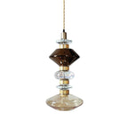 Sculptural glass pendant light with gold accents glowing
