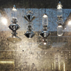 Handcrafted glass pendant light lit softly above a table