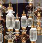 Glass pendant light with gold cable hanging in a room