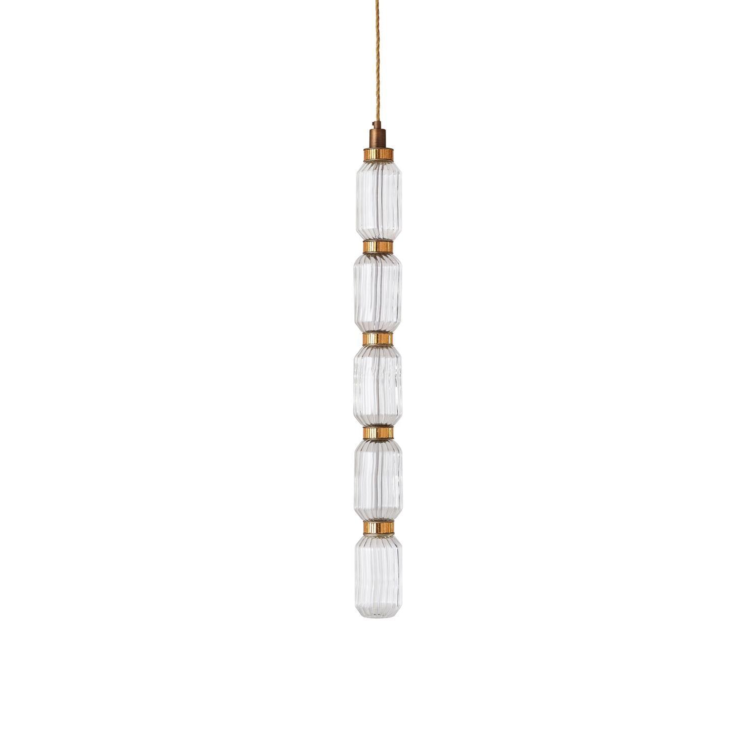 Ballet glass pendant light glowing above a table