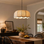Hanging above a rustic wooden dining table styled with foliage, this beige Clérachic pendant lamp shows its scalloped shade.