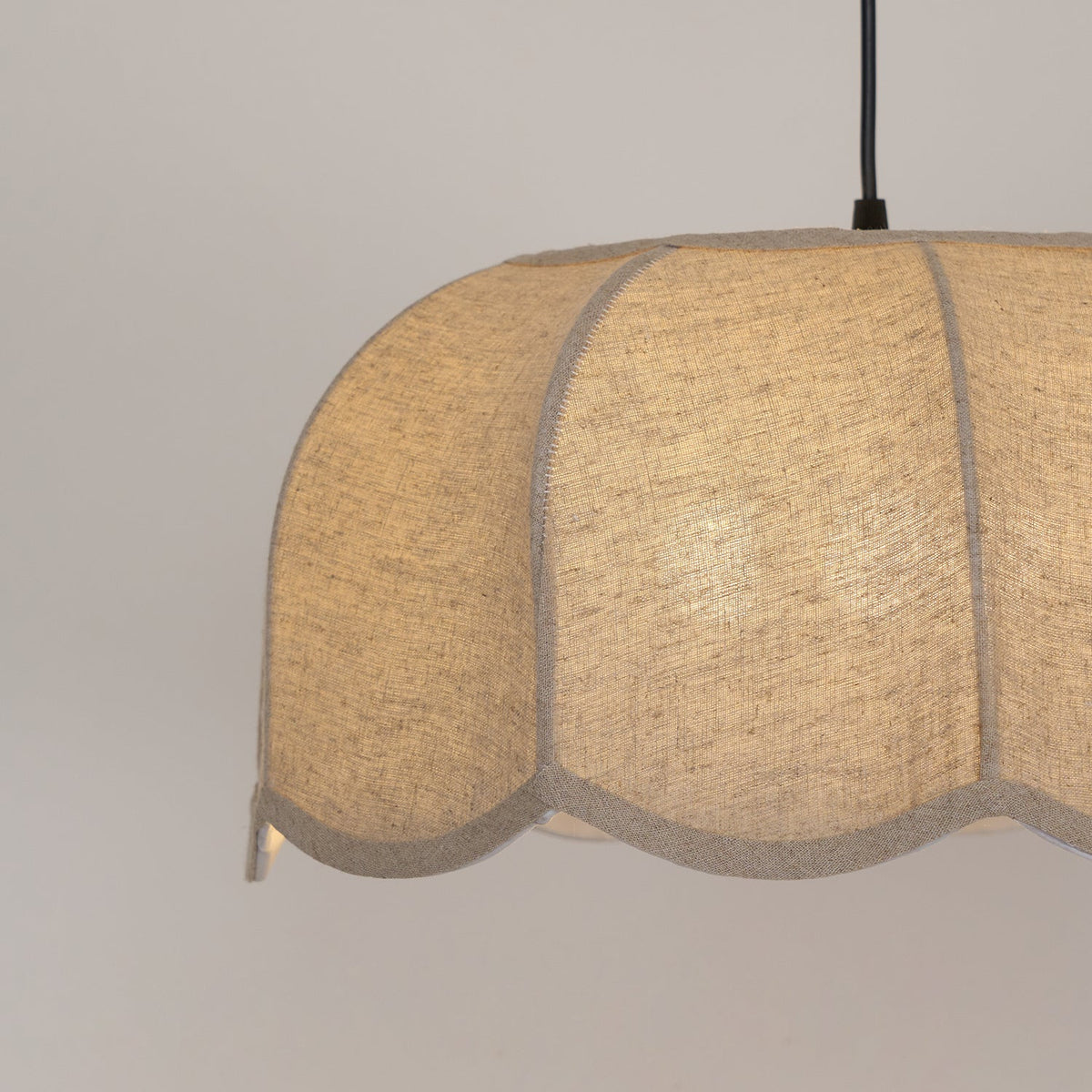 Close view of the fabric weave on this Clérachic pendant lamp's shade, lit softly from within.