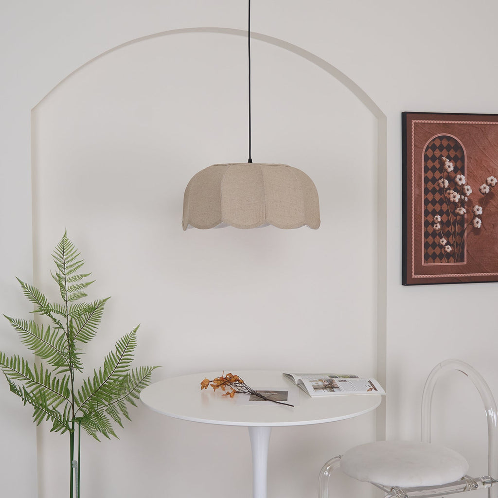 Seen from further back beneath the same arch, this Clérachic pendant lamp hangs high above a round table and fern sprig.
