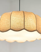 Close view of the scalloped shade's underside on this Clérachic pendant lamp, glowing white from within.