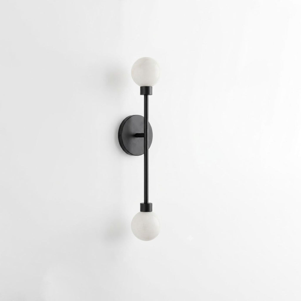 Studio shot of this Clérachic sconce in matte black finish, its alabaster ball shades on a slim rod.