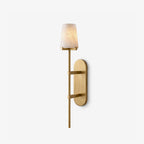 This brass Clérachic wall sconce shows its tall oval backplate and tapered alabaster shade on a plain white backdrop.