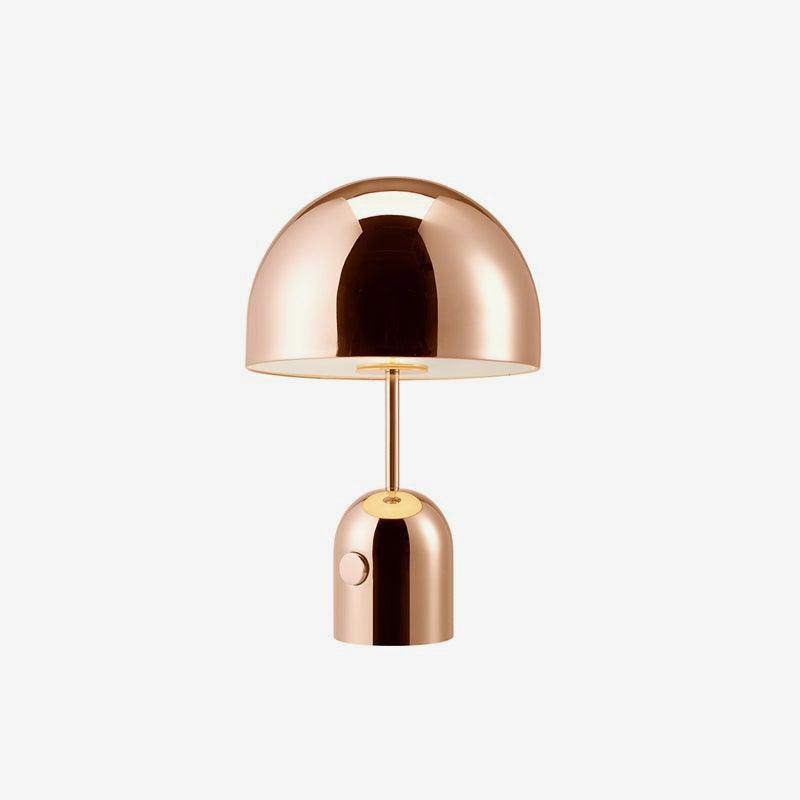 A plain product shot of this Clérachic table lamp in rose gold, dome shade and cylindrical base, on grey.