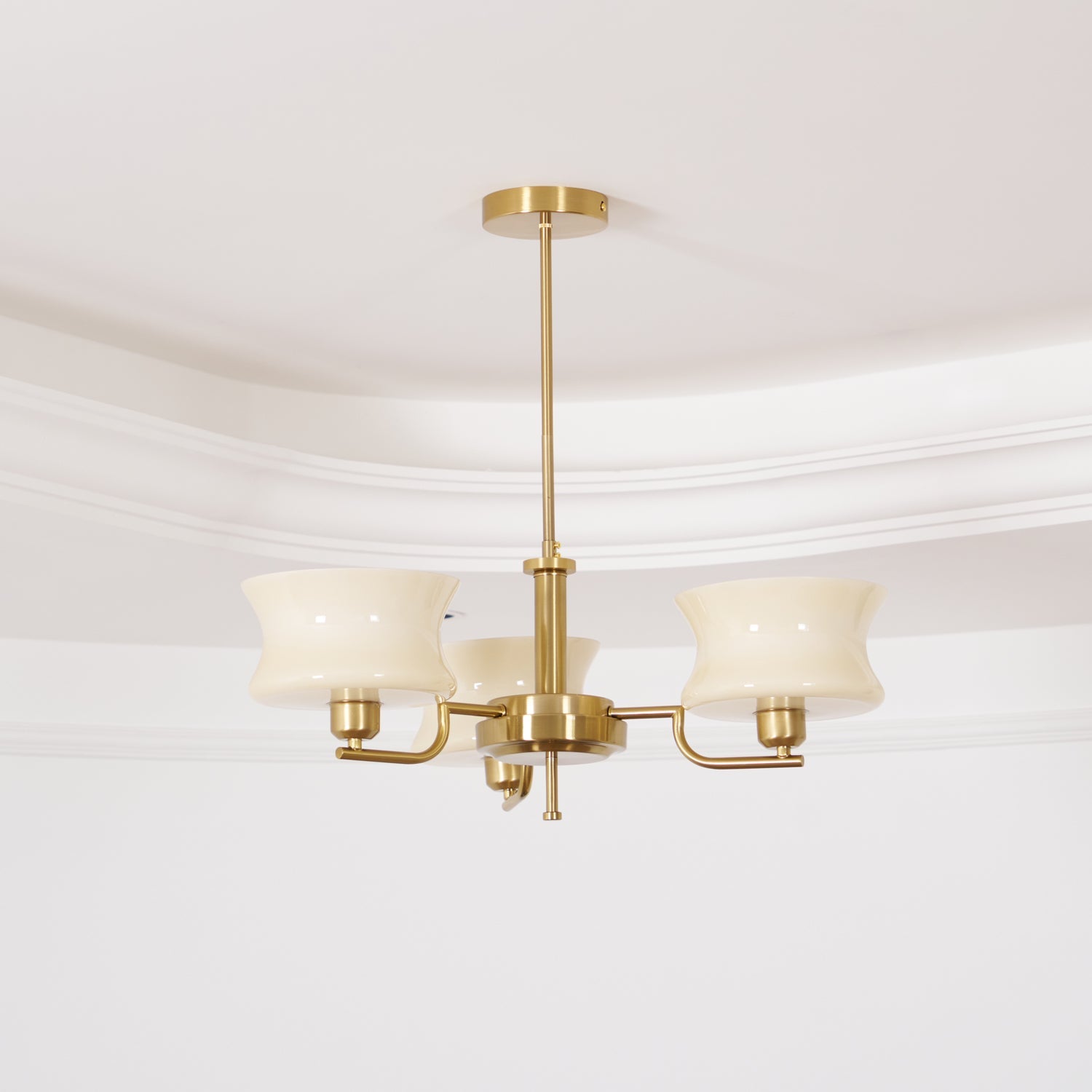 Three-head glass globe chandelier with beige shades and gold frame