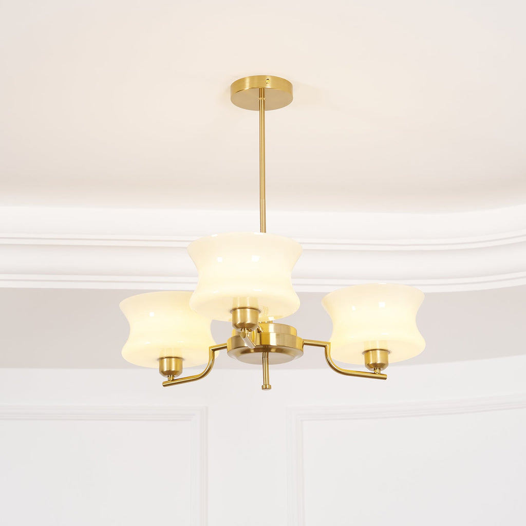 Glass globe chandelier in gold finish lighting a living room