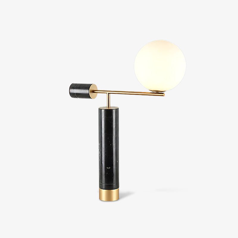 A Clérachic desk lamp on white with a soft shadow beneath its base, the glass globe glowing warm at the top of its arm.