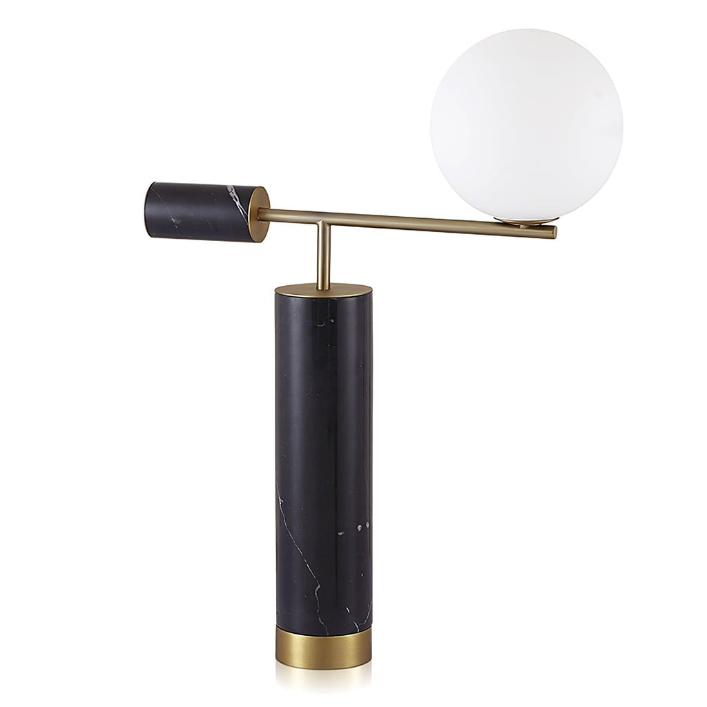 This Clérachic desk lamp is shown front-on against a white background, its glass globe glowing warm above the marble base.