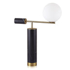 This Clérachic desk lamp is shown front-on against a white background, its glass globe glowing warm above the marble base.