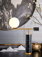 A closer crop of the same styled Clérachic desk lamp shot, showing the marble counterweight against the mirrored backdrop.