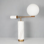 This Clérachic desk lamp in the white marble finish stands against a plain grey backdrop, its glass globe unlit.