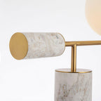Close-up of the white-marble Clérachic desk lamp's counterweight and base, showing the stone's warmer veining and gold cap.