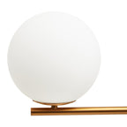 Close-up of the Clérachic desk lamp's plain glass globe resting on its gold arm, shown unlit against white.