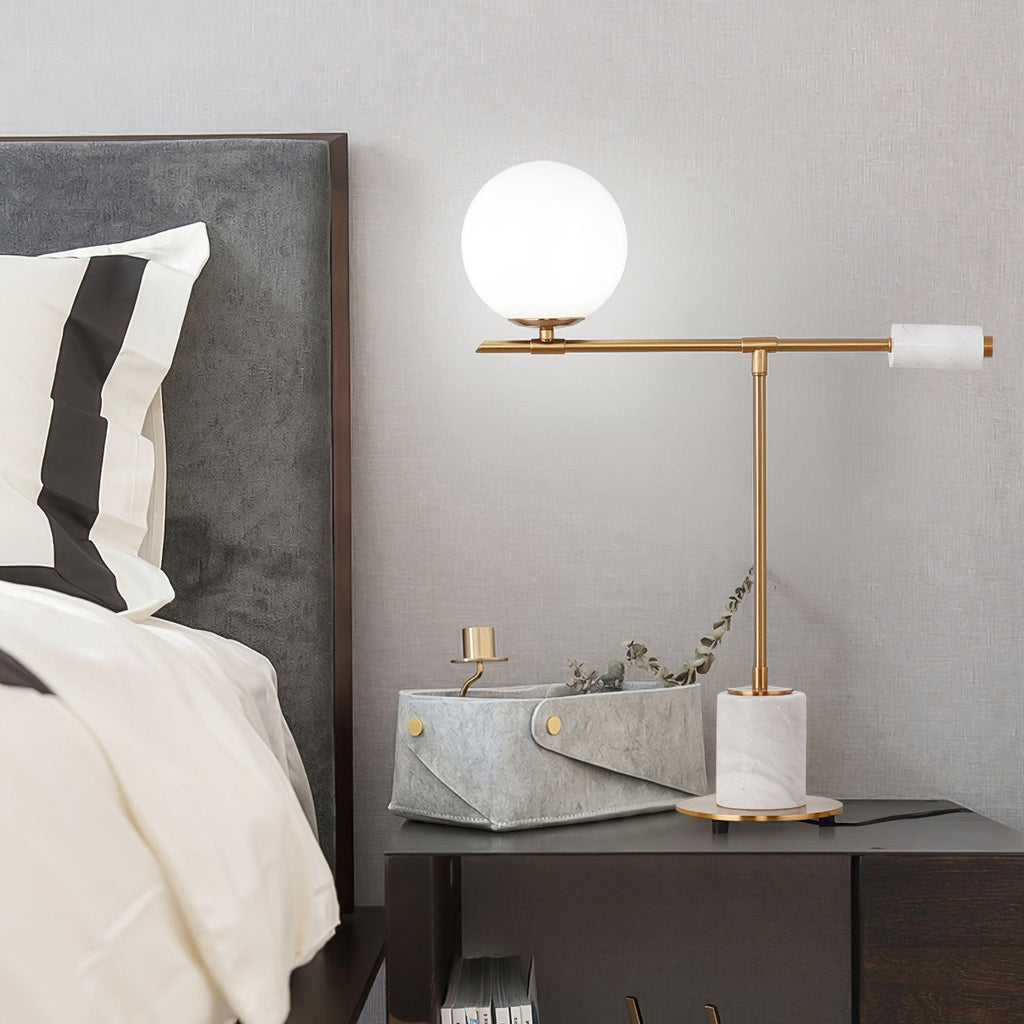 The white-marble Clérachic desk lamp glows on a grey nightstand beside a small woven basket and a trailing plant sprig.