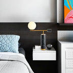 Another view of the Clérachic desk lamp on the same dark-panelled nightstand, cropped closer around the lit globe.