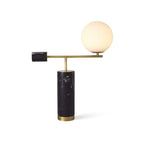 A small isolated shot of the Clérachic desk lamp on white, its glass globe unlit above the black marble base.