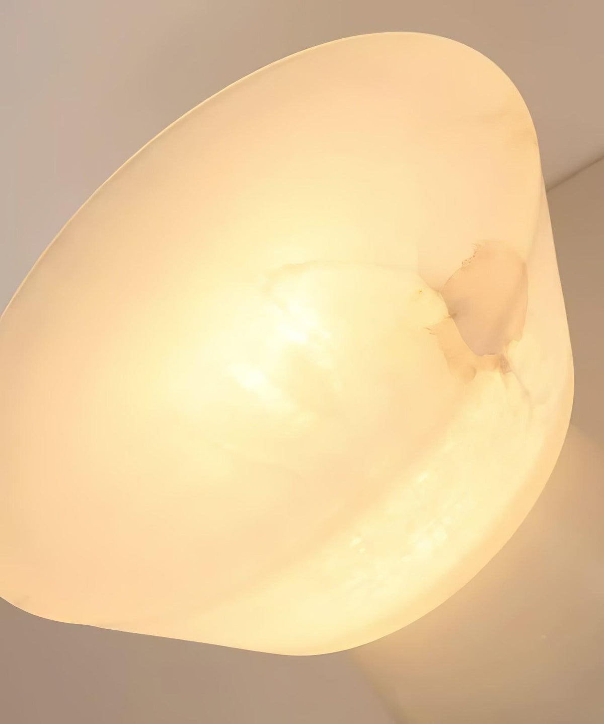 Extreme close-up of the Clérachic lamp's alabaster shade rim, showing the stone's natural veining lit from within.