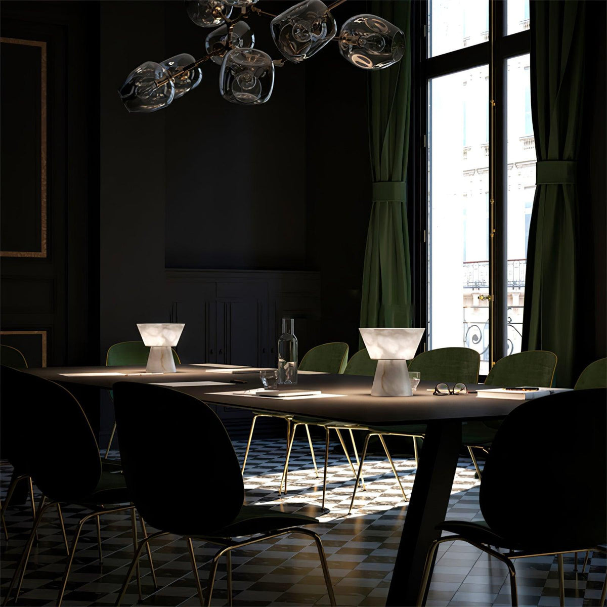 Two Clérachic alabaster table lamps lit on a set dining table with black chairs, pendant lights hanging above them.