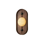 The wall light on white in a warmer stone tone, the alabaster disc reading pale gold.