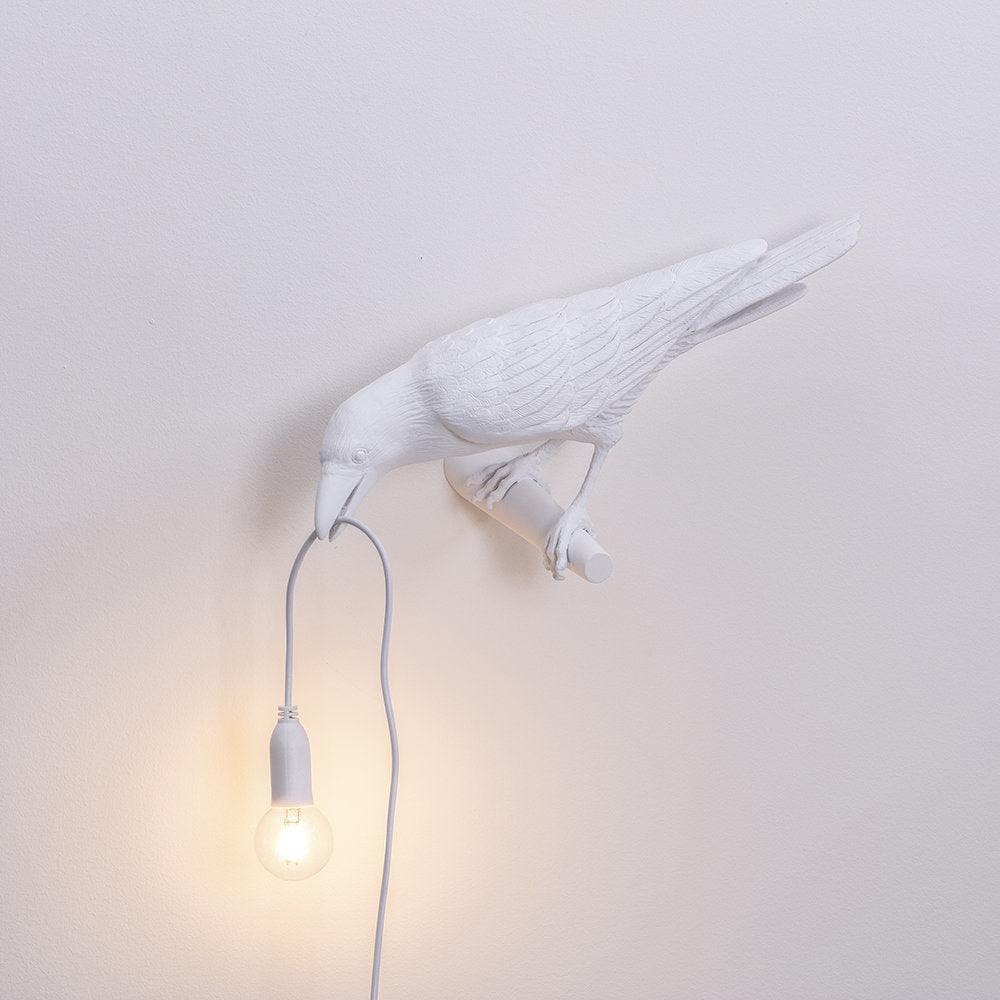 A tighter crop on the same white bird lamp shows the warm bulb glow beneath its beak, from Clérachic, on plain white.